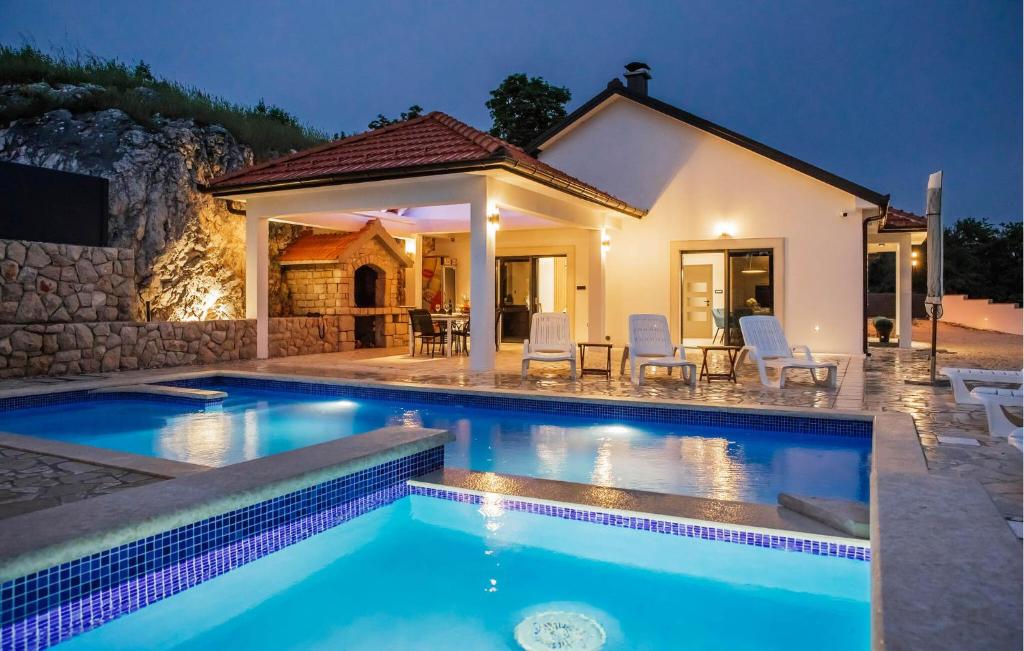 een villa met een zwembad en een huis bij Lovely Home In Gornji Prolosac With Outdoor Swimming Pool in Gornji Proložac