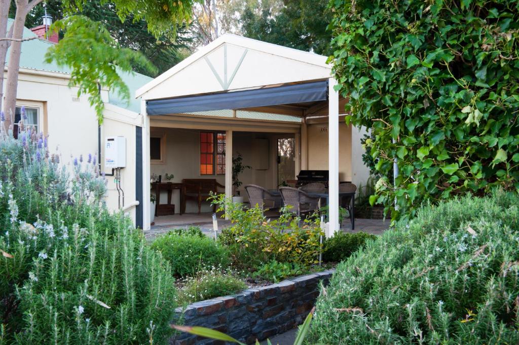 a pavilion with a table and chairs in a garden at Linfield Cottage in Williamstown