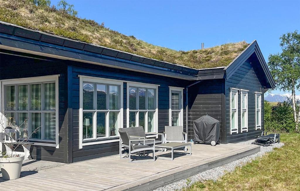 a blue house with two chairs on a wooden deck at Awesome Home In Stranda With Wifi in Stranda