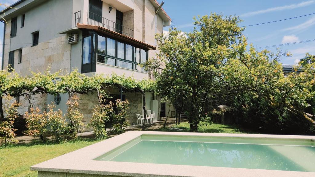 ein Haus mit einem Pool vor einem Haus in der Unterkunft Villa San Martín in Mondariz