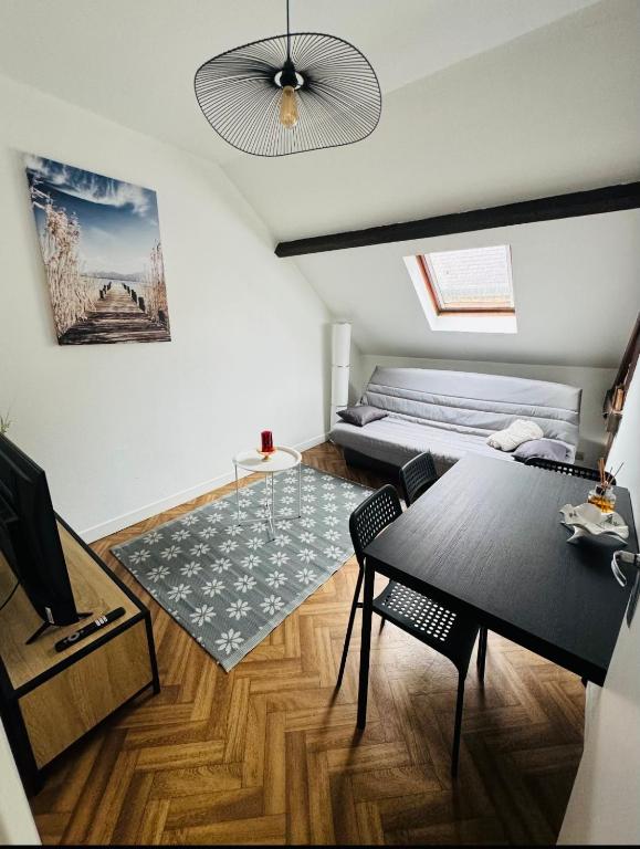 un salon avec un lit et une table dans l'établissement Morgan' Appartement, à Laon