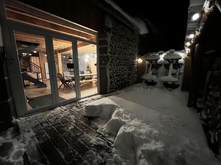 une chambre avec de la neige au sol et une fenêtre dans l'établissement La Grange de la Gratade, à Rochefort-Montagne