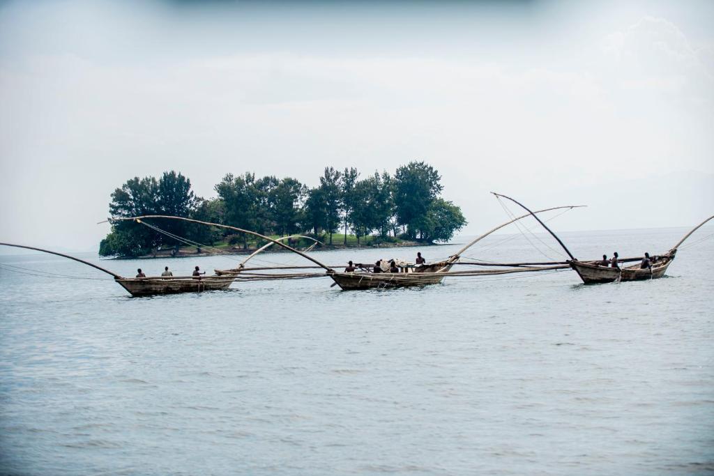 zwei Boote mit Menschen, die im Wasser fischen in der Unterkunft Paradis Malahide in Gisenyi