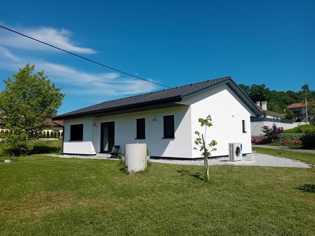 a white house with a small tree in the yard at Dantin guest house in Prvačina