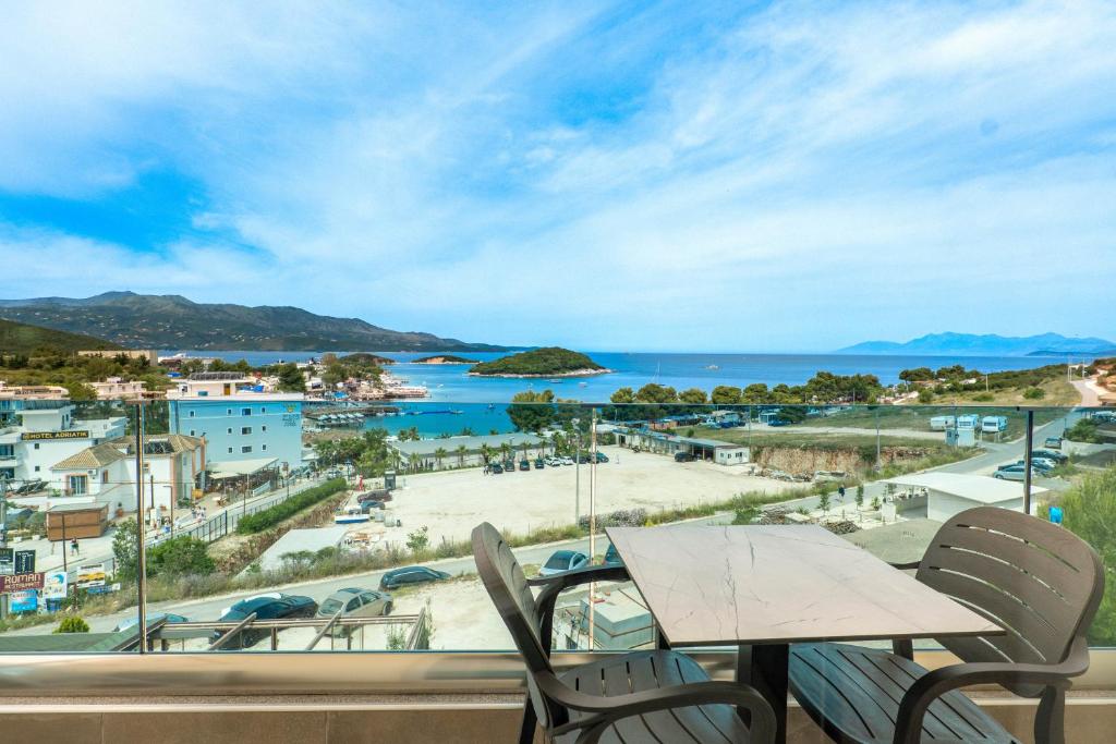 balcón con mesa, sillas y vistas al océano en Hotel Afa, en Ksamil