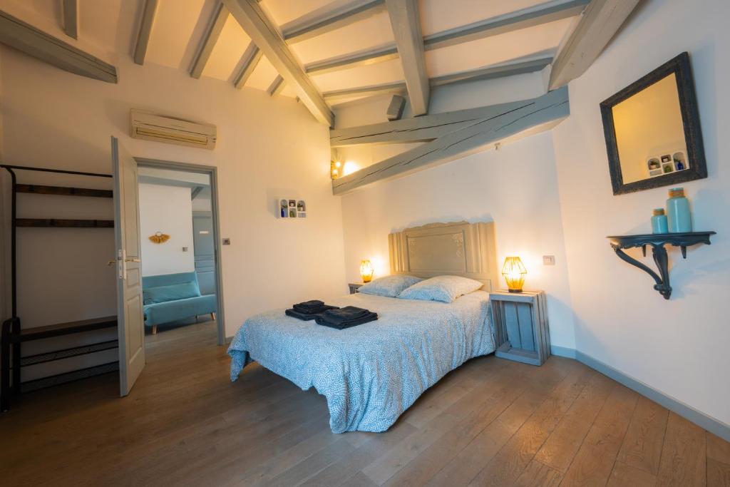 a bedroom with a bed with a blue blanket at Chez la fille de l éclusier in Castelnaudary