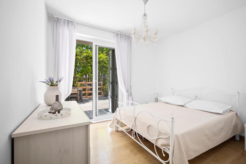 Un dormitorio blanco con una cama y un balcón. en City Vibe Villa with pool, en Split