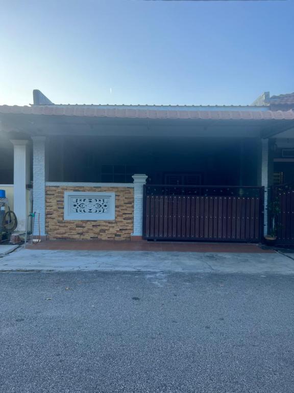 a house with a fence and a sign on it at Adhwa Homestay in Kampong Bukit Katil