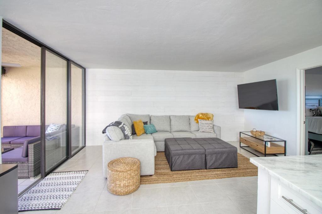 ein Wohnzimmer mit Sofa und Fernseher in der Unterkunft Island Whispers Hideaway in Marco Island