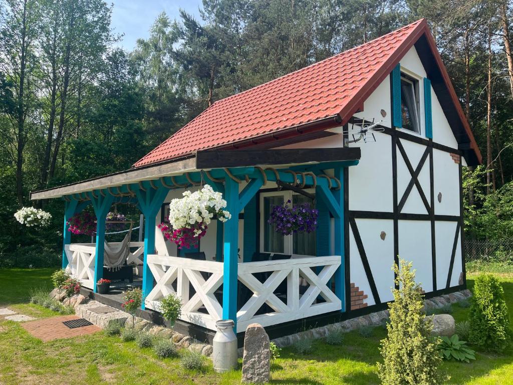 a small white and blue building with a red roof at Domek wakacyjny Wczasy jak Marzenie in Ruciane-Nida