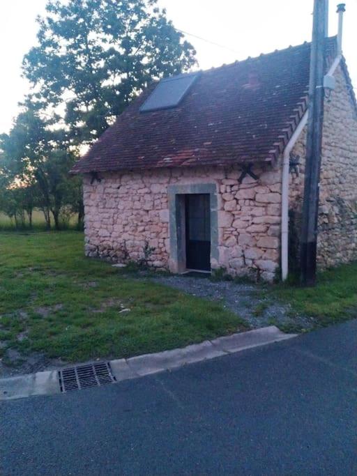 un ancien bâtiment en pierre avec une porte dans un champ dans l'établissement La Petite Maisonnette des Amoureux, à Chitray