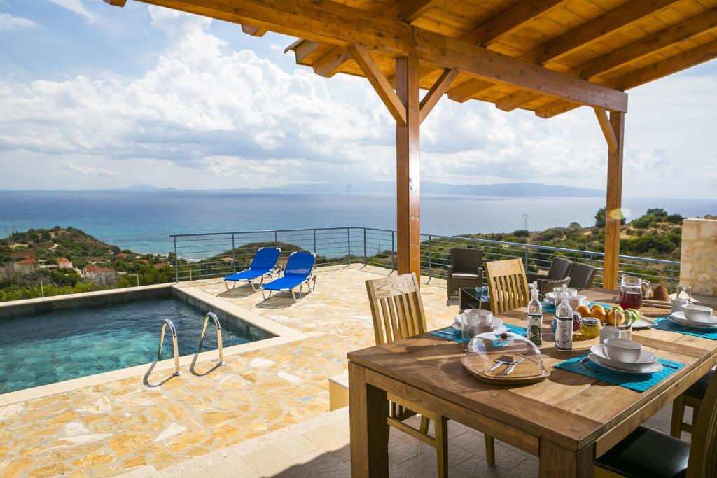 a dining table with a view of the ocean at Unique Villa Ratzakli in Ratzaklíon