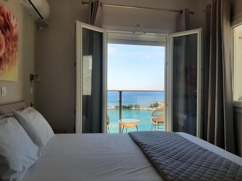 a bedroom with a bed and a view of the ocean at OLYMPIADA View 1 in Pythagoreio