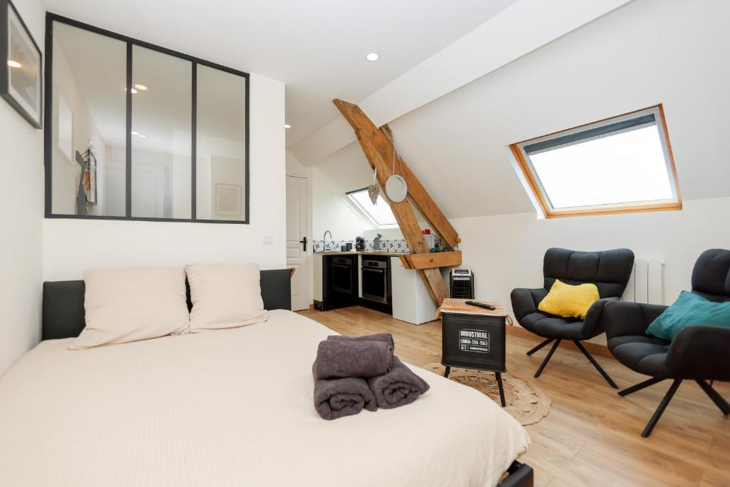 une chambre avec un lit et deux chaises dans l'établissement Ma parenthèse, à Wimereux