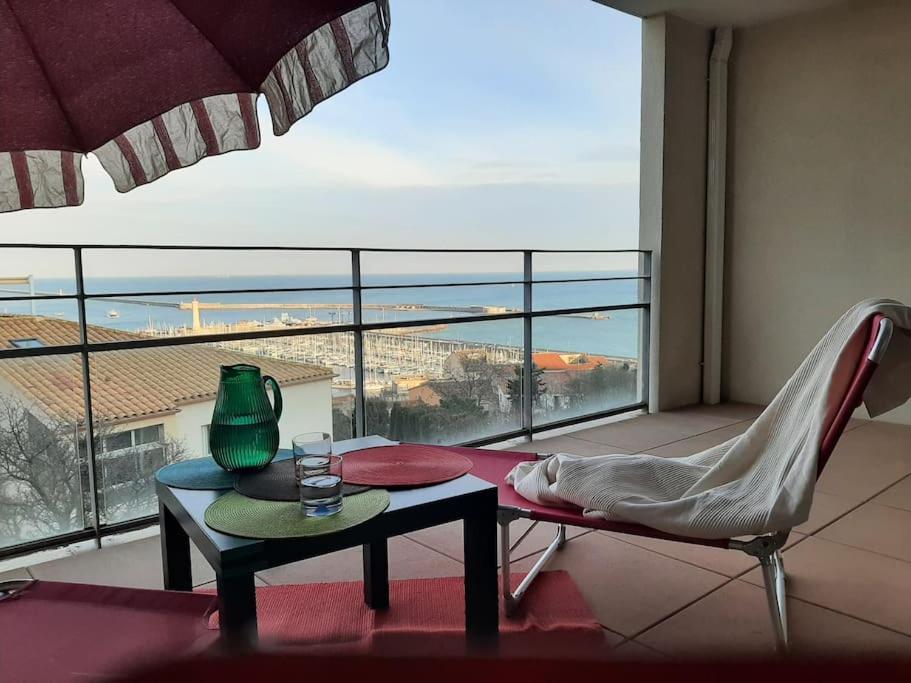 - un salon avec une table, une chaise et une fenêtre dans l'établissement Le Phare au cap Saint Clair, à Sète