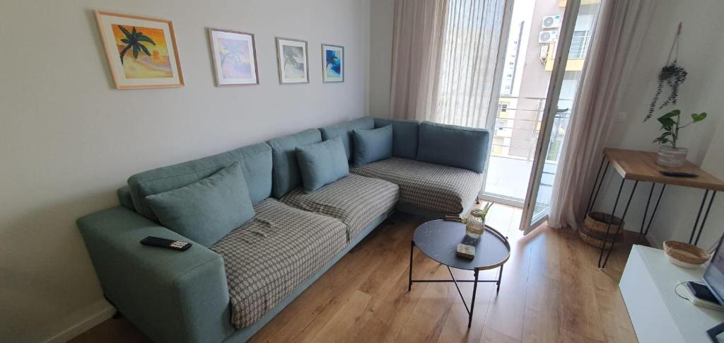 uma sala de estar com um sofá azul e uma mesa em Erli's Apartment em Golem