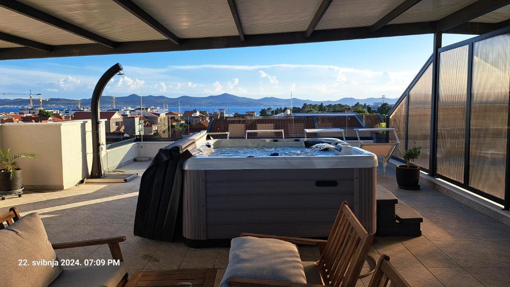 a hot tub on a balcony with a view of the city at Apartment Bruno - Luxury Penthouse with Jacuzzi in Zadar