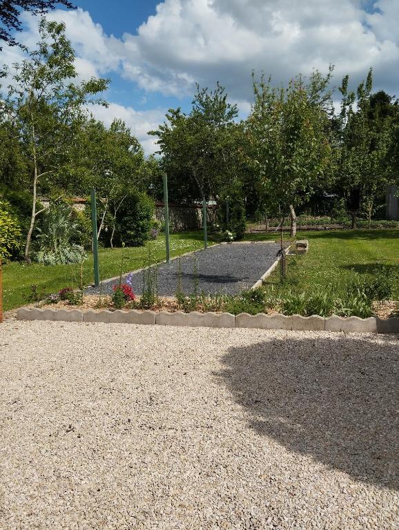 une allée en gravier avec un parc en arrière-plan dans l'établissement Le vieux tilleul, à Fère-en-Tardenois