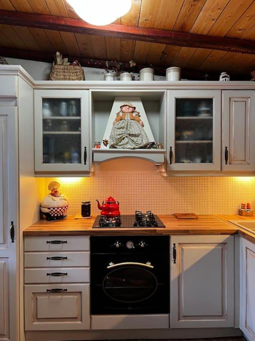 a kitchen with white cabinets and a black oven at Aelia Cottage House in Khrónia