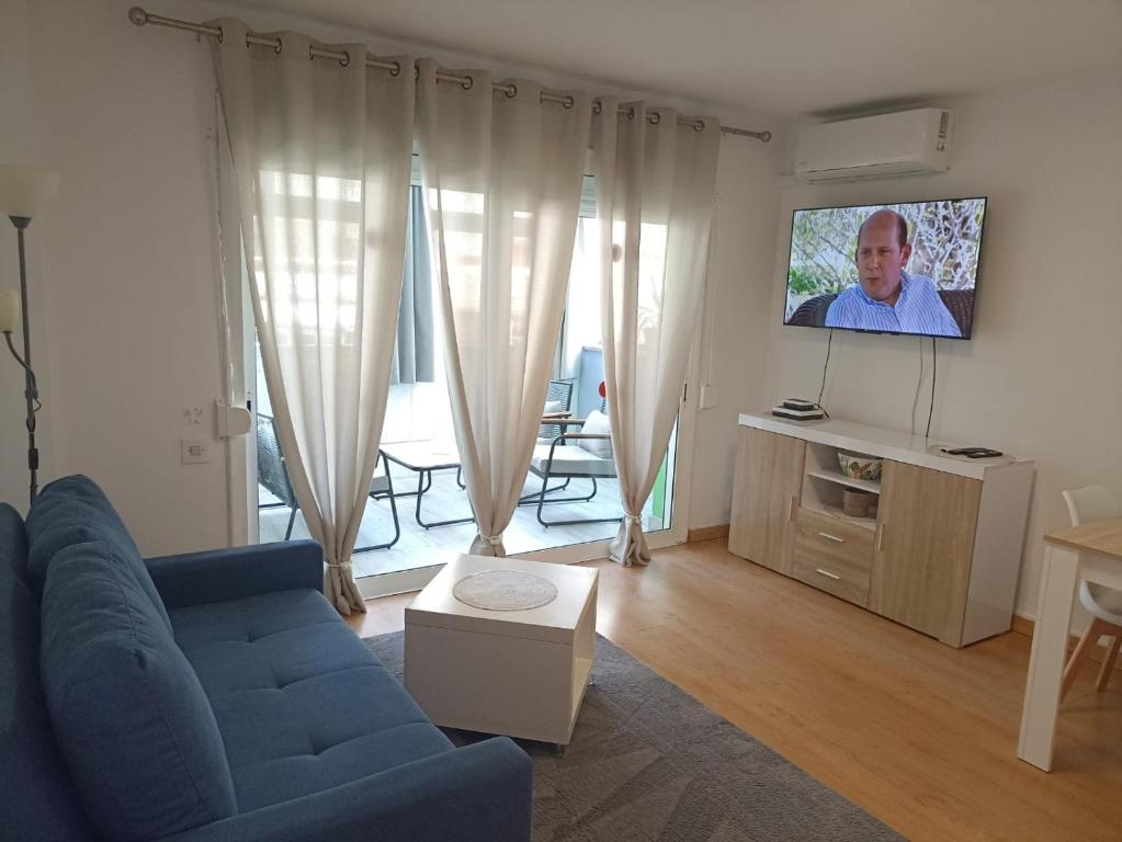 a living room with a blue couch and a flat screen tv at Brisas del Mar in Salou