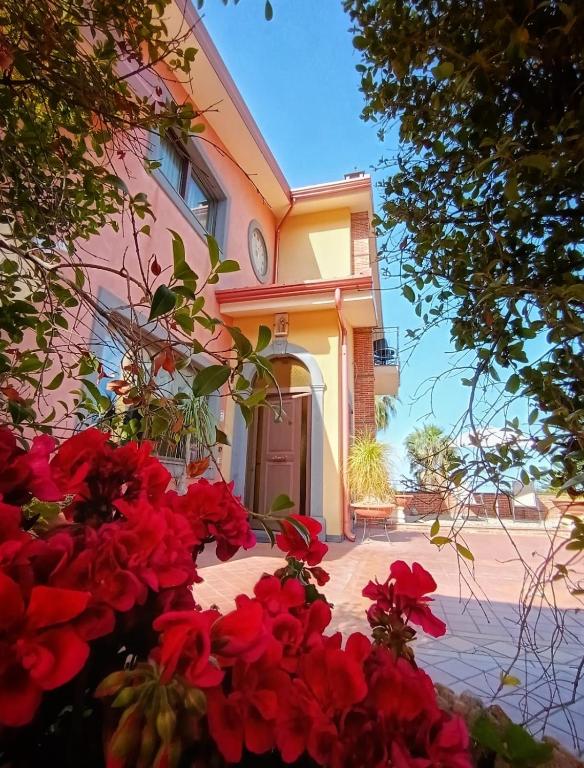 a house with red flowers in front of it at Villa Hirschen in Zafferana Etnea