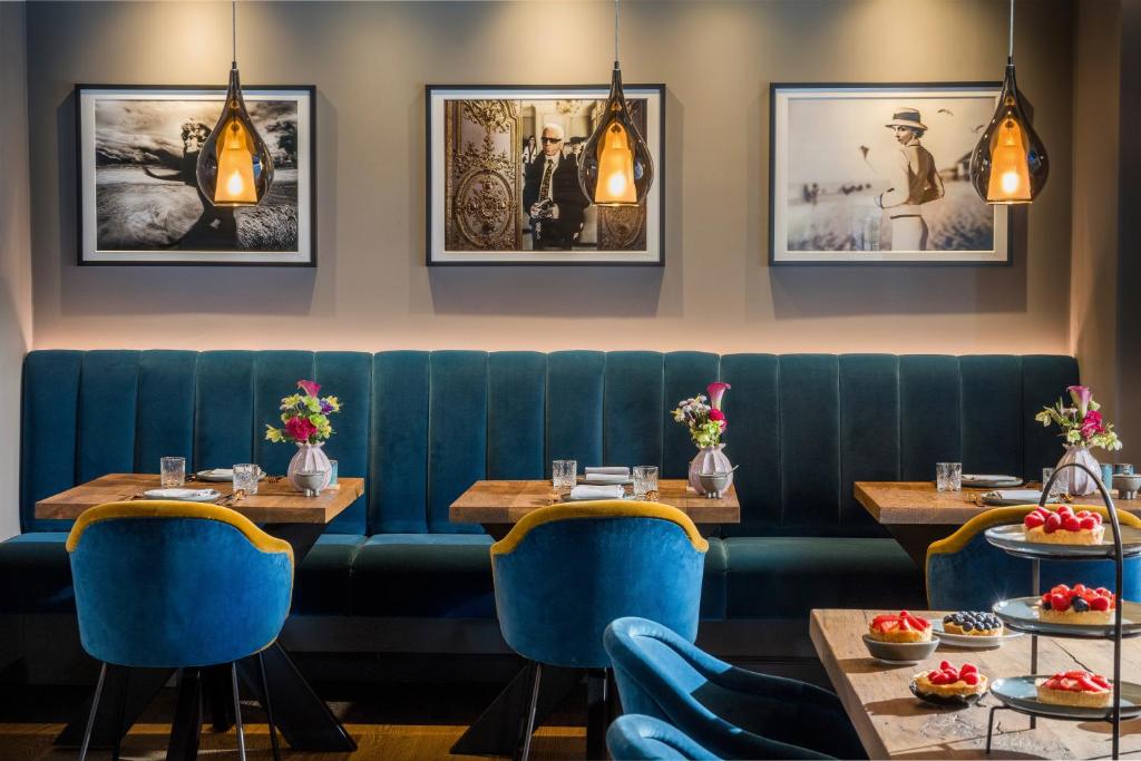 un restaurante con 2 mesas y sillas azules en Hotel Atlantic, en Westerland