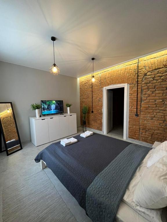 a bedroom with a large bed and a brick wall at St Benedict Apartments in Lviv