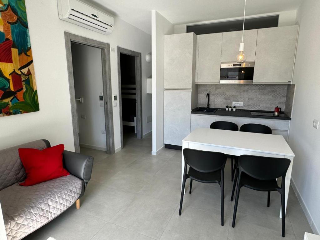 Una sala de estar con mesa y sillas y una cocina. en Da Monnedda, en Cala Gonone