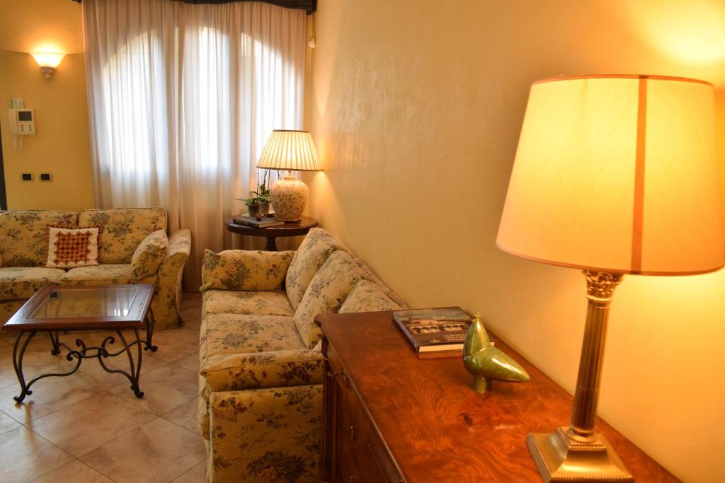 una sala de estar con sofá y una lámpara en una mesa. en Magenta Apartment, en Florencia