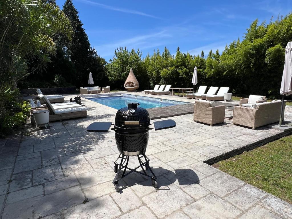 a grill on a tripod next to a swimming pool at Luxurious royal estate in historic Sintra paradise in Sintra