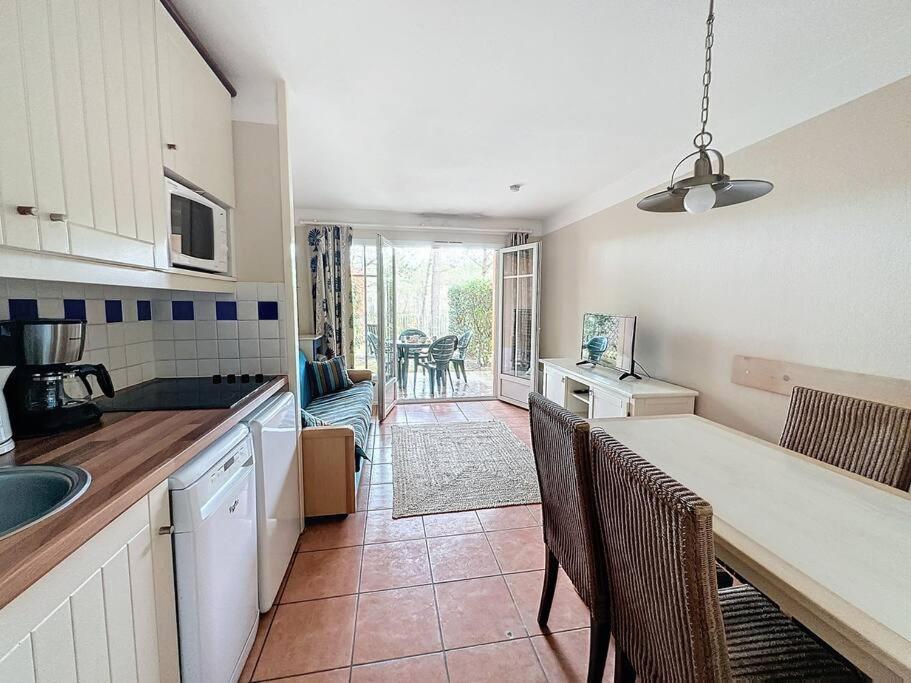 une cuisine avec un comptoir et une table avec des chaises dans l'établissement Appartement à 2 pas océan et lac, à Lacanau