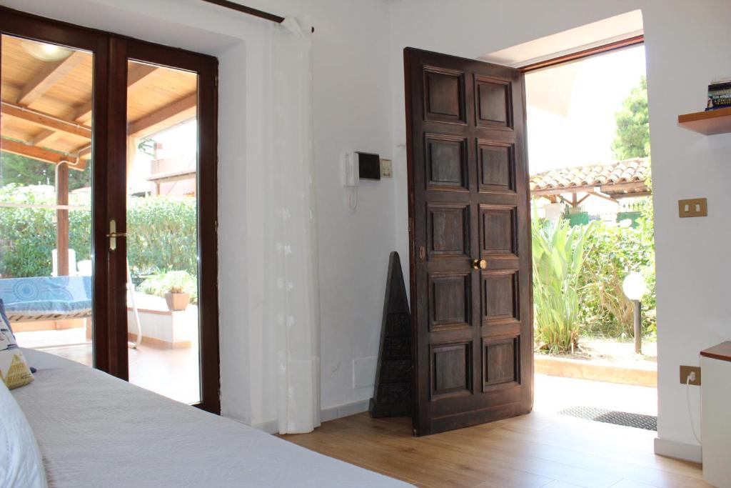 een slaapkamer met een deur naar een patio bij mare, sole e relax a 5 km da Cefalu' in Cefalù