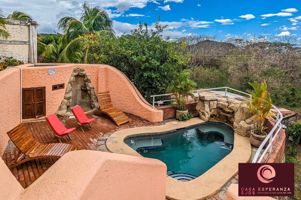 uma piscina de resort com escorrega e 2 cadeiras em Casa Esperanza SJDS em San Juan del Sur