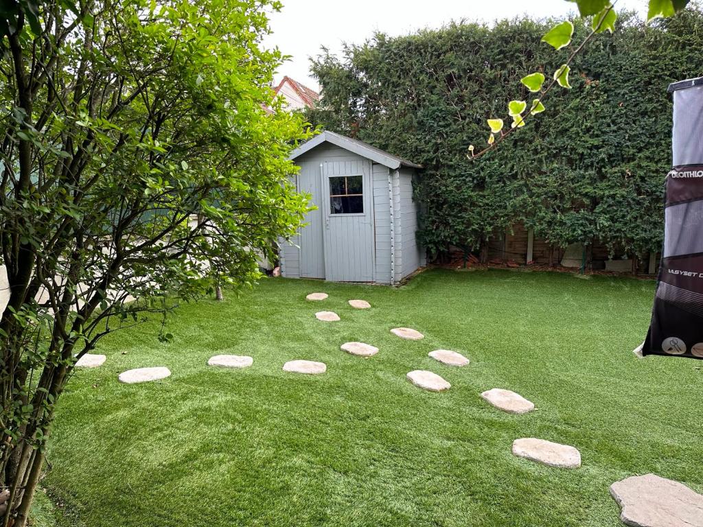un jardin avec des rochers dans l'herbe avec un abri dans l'établissement Maison Mont Valérien proche Paris la Défense Rueil, à Nanterre
