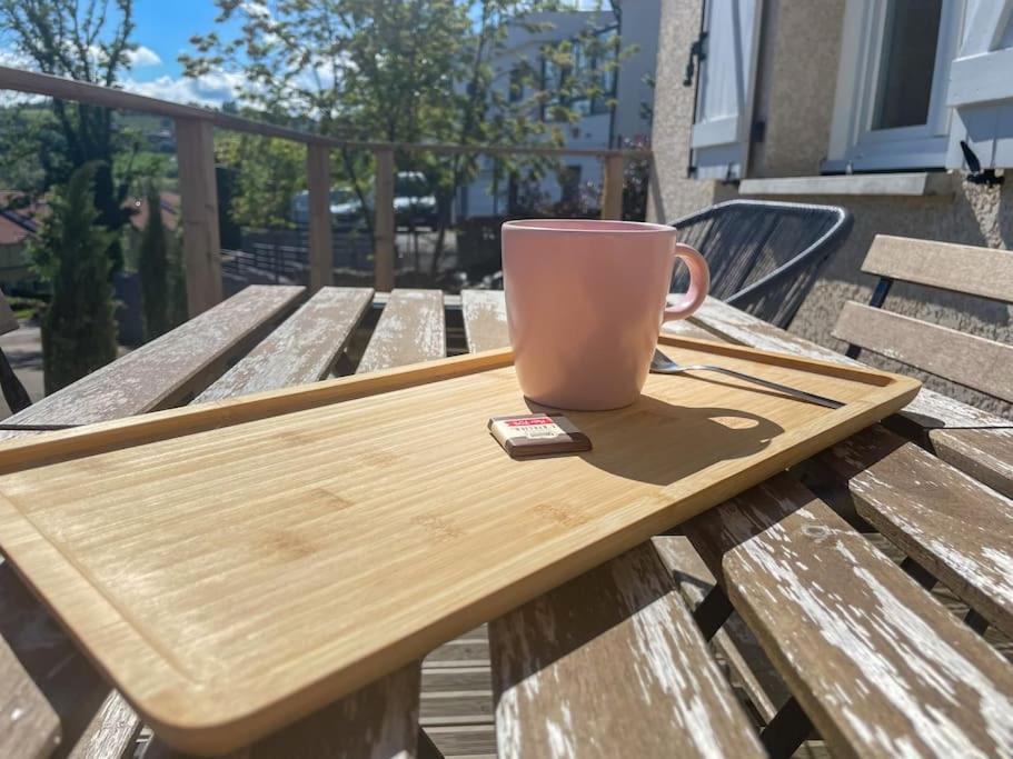 a coffee cup sitting on a wooden table at Joli petit appartement. in Saint-Genest-Lerpt