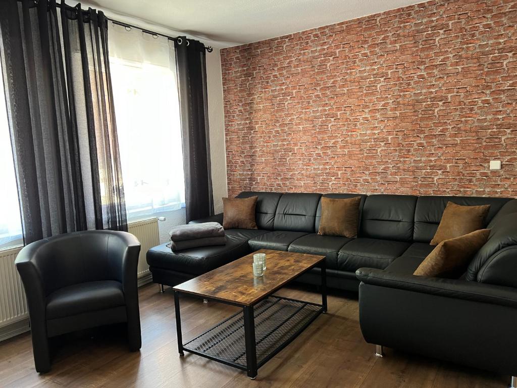 a living room with a couch and a brick wall at Ferienwohnung Nauen Familie Renner in Nauen