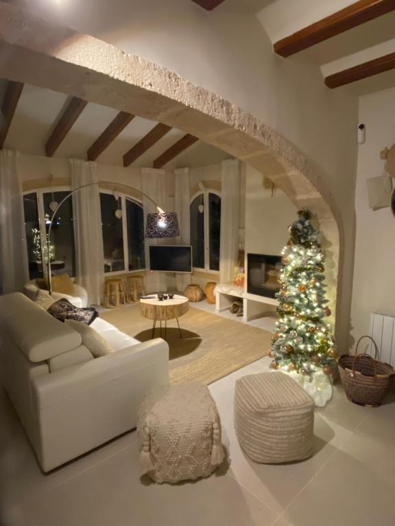 a living room with a christmas tree and a white couch at Casa El Sueño in Jávea