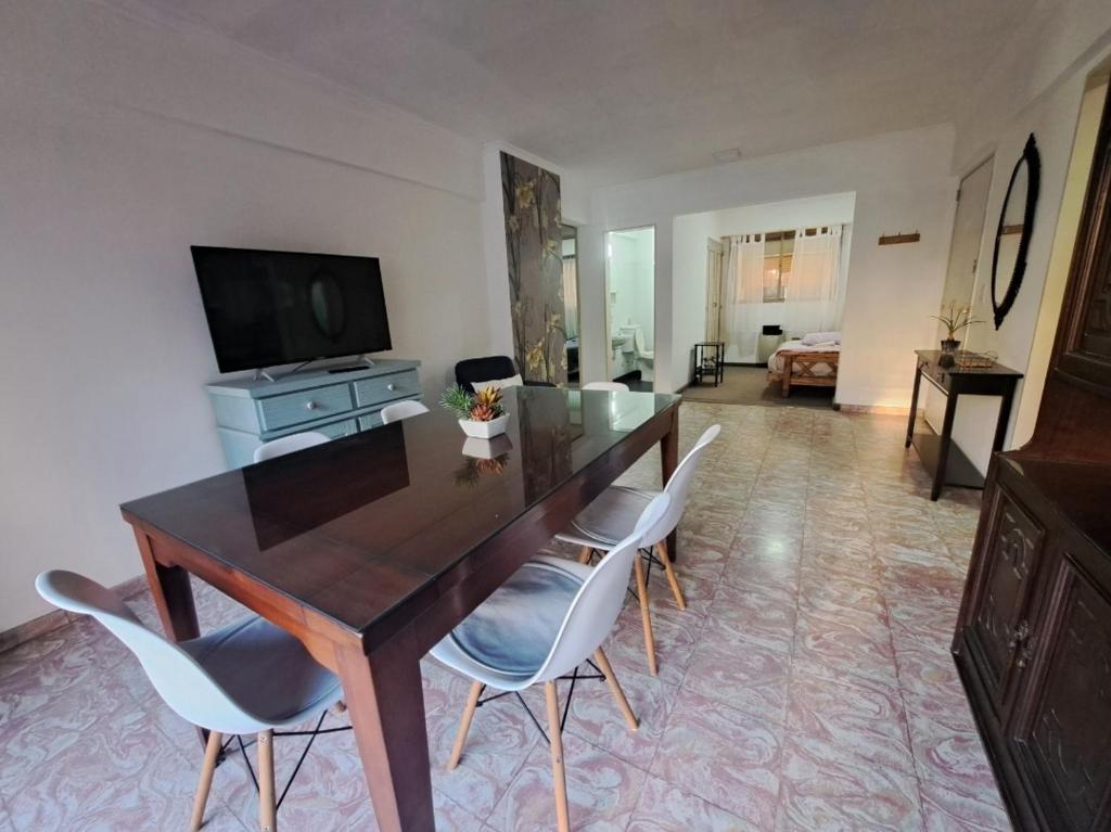 Una sala de estar con una mesa y sillas de madera. en Plaza 23, en Bahía Blanca