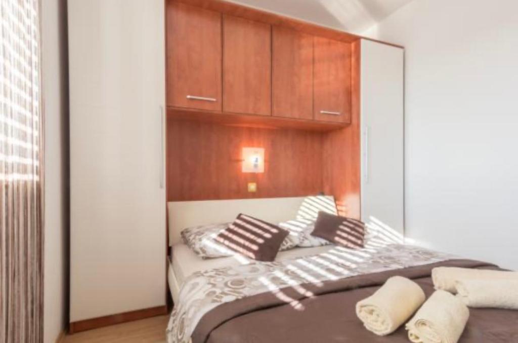 a bedroom with a large bed with wooden cabinets at Apartmani Maja Vrsi in Vrsi