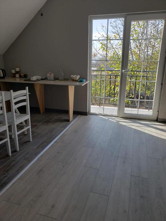 an empty room with a table and a large window at Apartment Natura in Tbilisi City