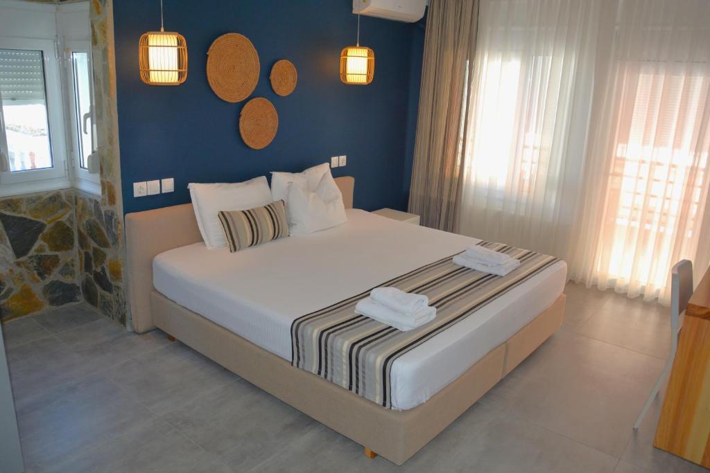 奧林匹亞基·阿克蒂的住宿－Virginia Rooms，一间卧室配有一张带蓝色墙壁的大床