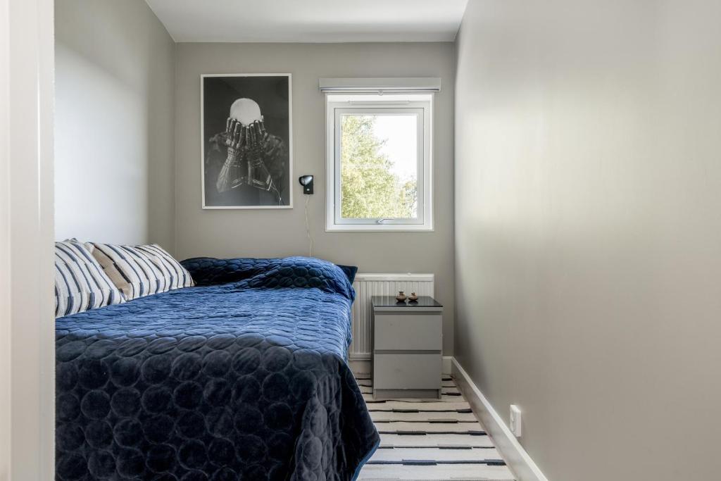 Lundby في Finspång: غرفة نوم بسرير ازرق ونافذة
