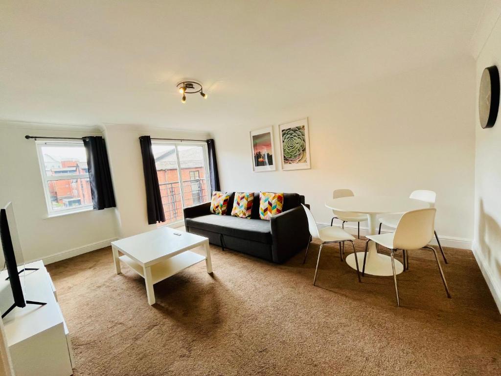 a living room with a couch and a table at Exquisite City Centre Apartment - 2 Bed 2 Bath - Free Parking - Netflix Amazon Disney Enabled Smart TV in Birmingham