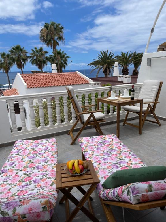 een balkon met stoelen en een tafel met fruit erop bij Ocean View near the Beach in Adeje