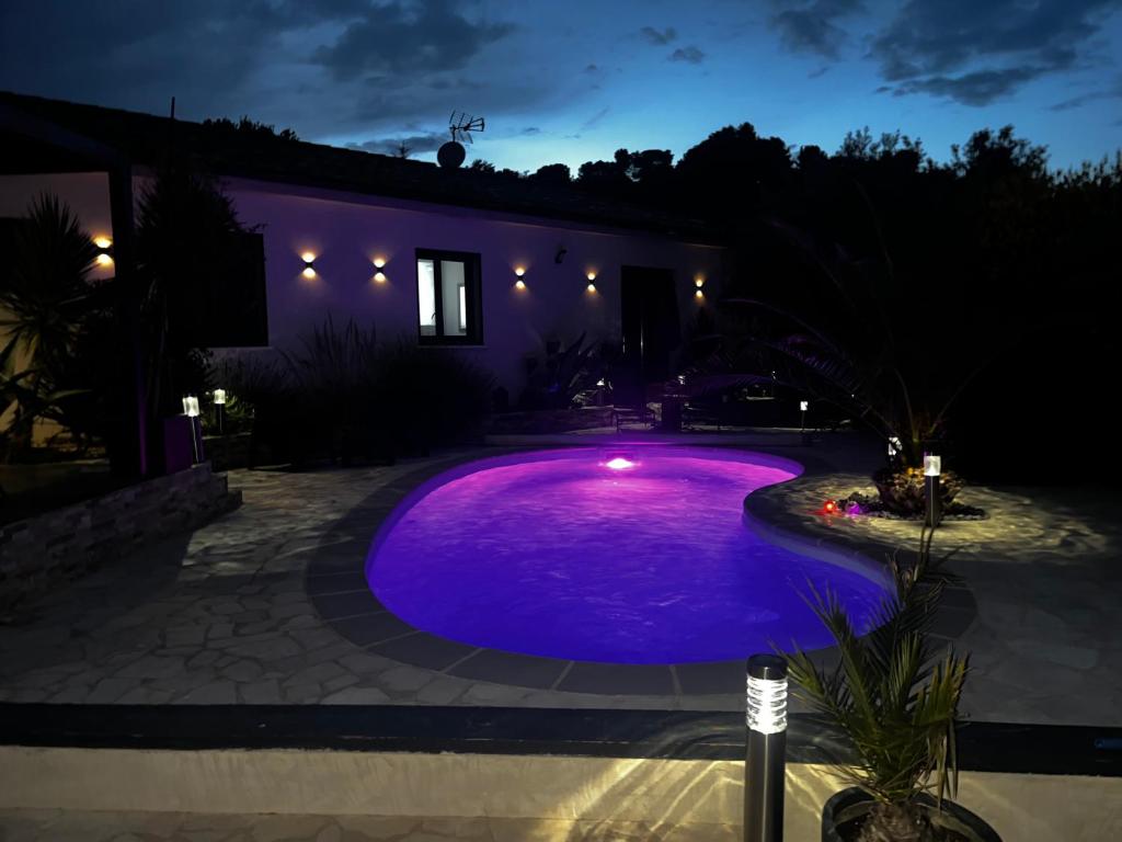 una piscina en un patio por la noche en Partie de villa moderne avec piscine En option jaccuzi dans espace détente indépendant, en Villeneuve