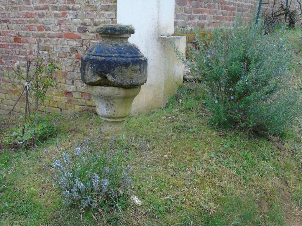 un vase en pierre posé à côté d'un mur de briques dans l'établissement Petit Argousier, à Cambron