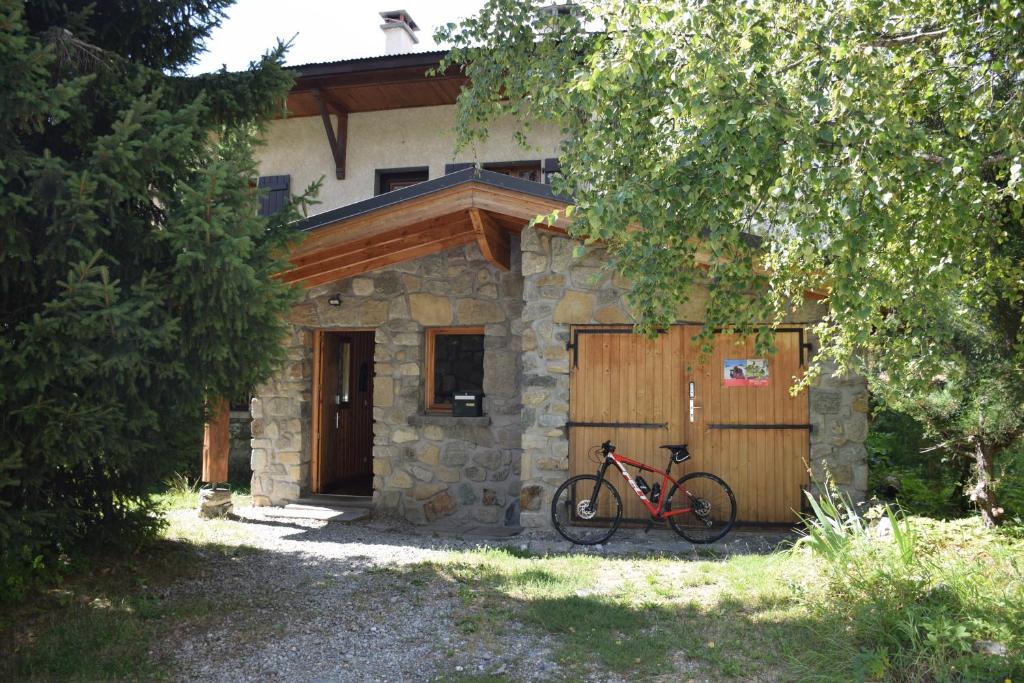 un vélo garé devant une maison dans l'établissement Chalet L Olan 15p Emplacement exceptionnel grand terrain, à Les Deux Alpes