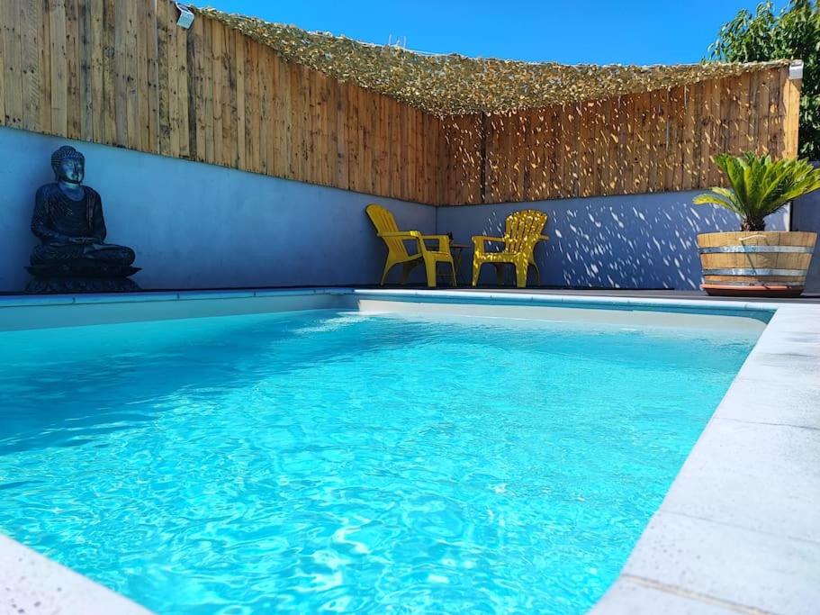 - une piscine d'eau bleue avec des chaises jaunes dans l'établissement Villa familiale en Provence, à Beaucaire