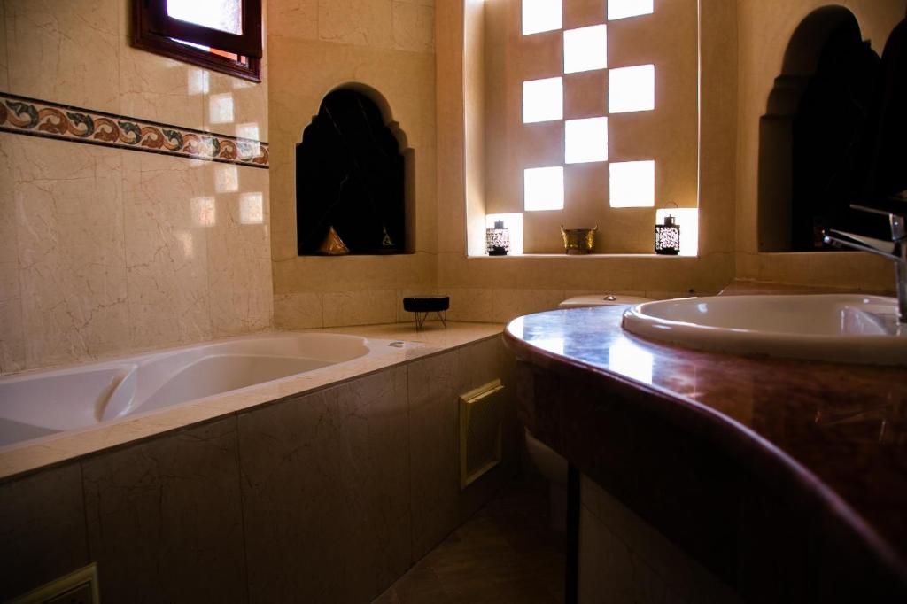 La salle de bains est pourvue de 2 lavabos et d'une baignoire. dans l'établissement Zine Villa Guest House, à Marrakech