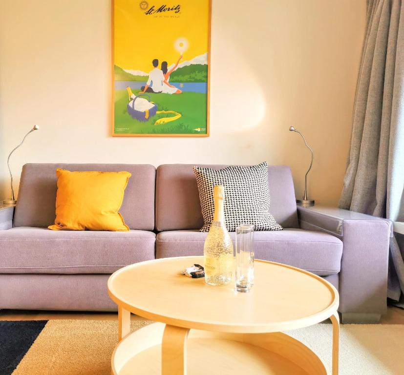 サンモリッツにあるSankt Moritz Spirit Piz Mezdi 15の紫色のソファとテーブル付きのリビングルーム